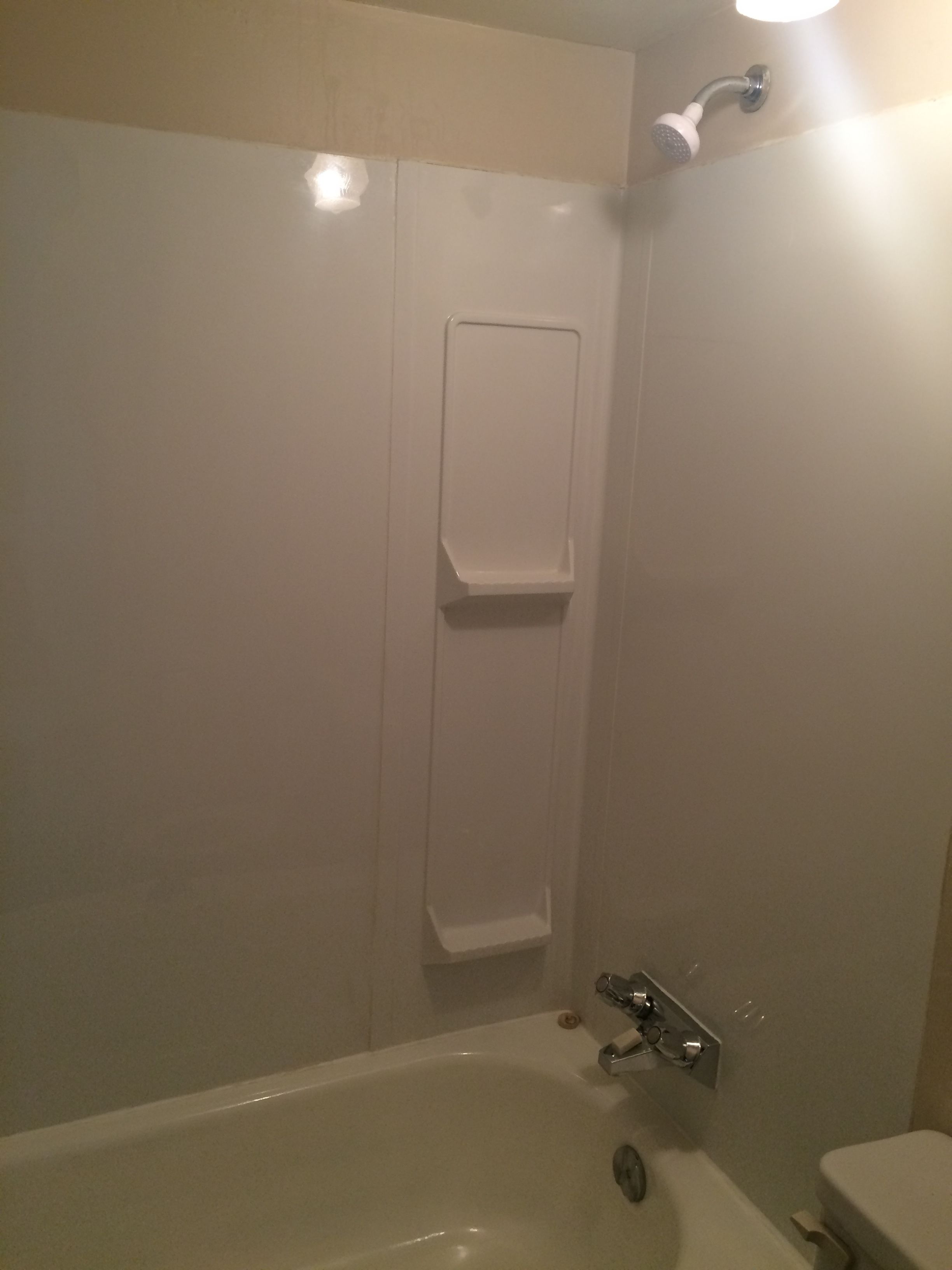 A bathroom with a bathtub, a toilet, and a shower with a towel rack.