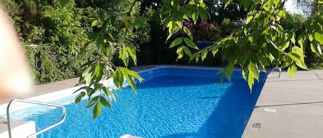 Piscine extérieure en saison, chaises longues