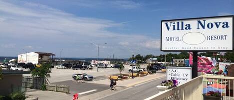 A sign for Villa Nova Motel & Resort with a view of the parking lot and street.