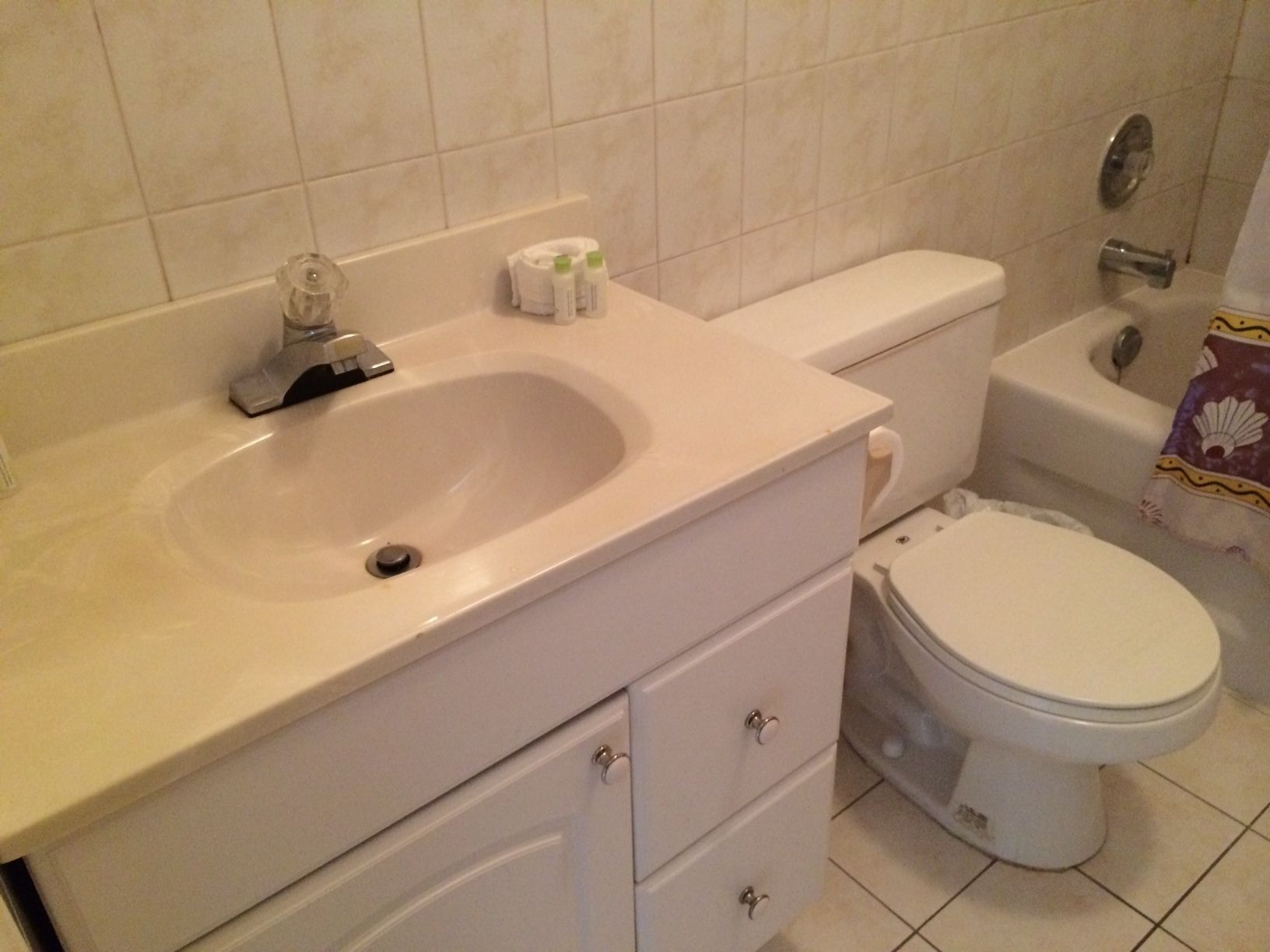 A bathroom with a sink, toilet, and a shower area.