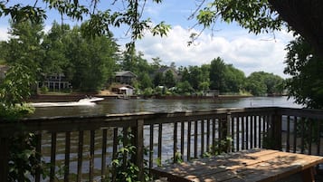 Enjoy a tranquil riverside setting with a wooden deck and picnic table overlooking the waterway.