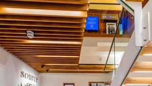 A modern interior with a wooden ceiling, a reception desk, a staircase, and a glass railing. - The Belmont Hotel - Adults Only (Sidmouth)