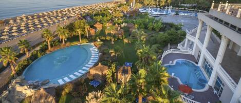 Een binnenzwembad, 8 buitenzwembaden en parasols bij het zwembad