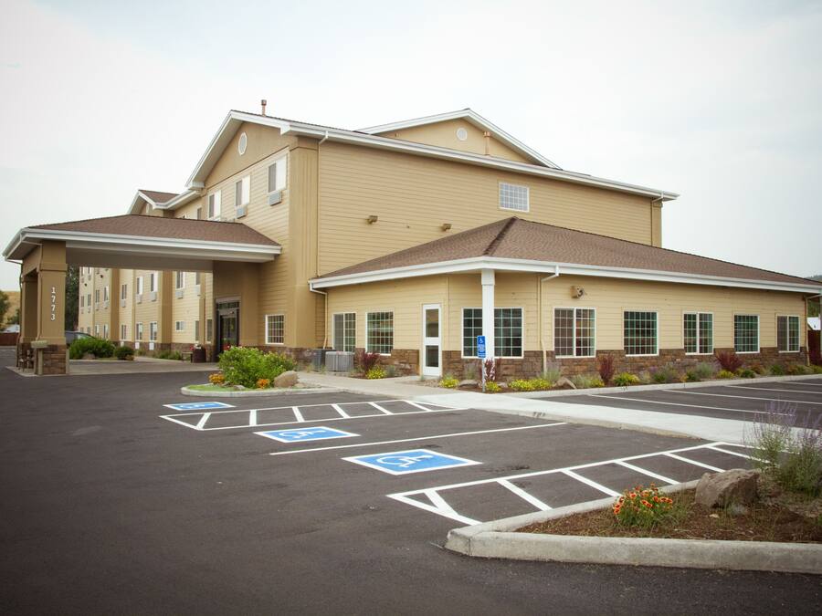 A multi-story building with a parking lot featuring handicapped parking spaces.