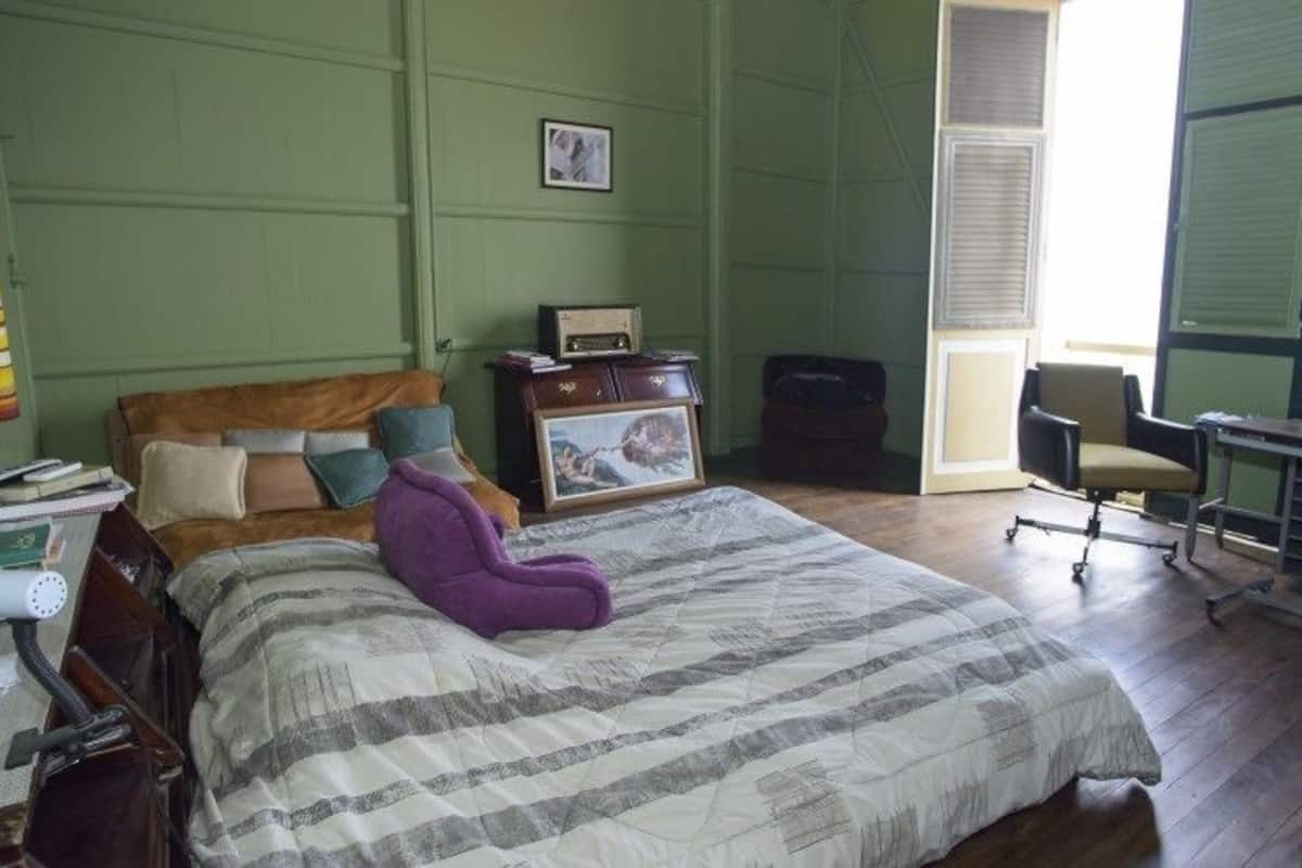 Ein Zimmer mit einem Bett, einem Schreibtisch, einem Stuhl und einer Lampe.