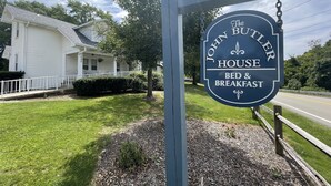 Señal anunciando The John Butler House, que ofrece servicios de alojamiento y desayuno.