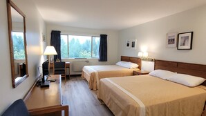 A hotel room with two beds, a desk, a chair, a lamp, and a large window with curtains. - Ridgeview Motor Inn (Gold River)