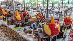 An outdoor dining area with tables set for a meal, surrounded by chairs and covered by a canopy. - Golden Sun Hotel Adult Only  (Kemer)