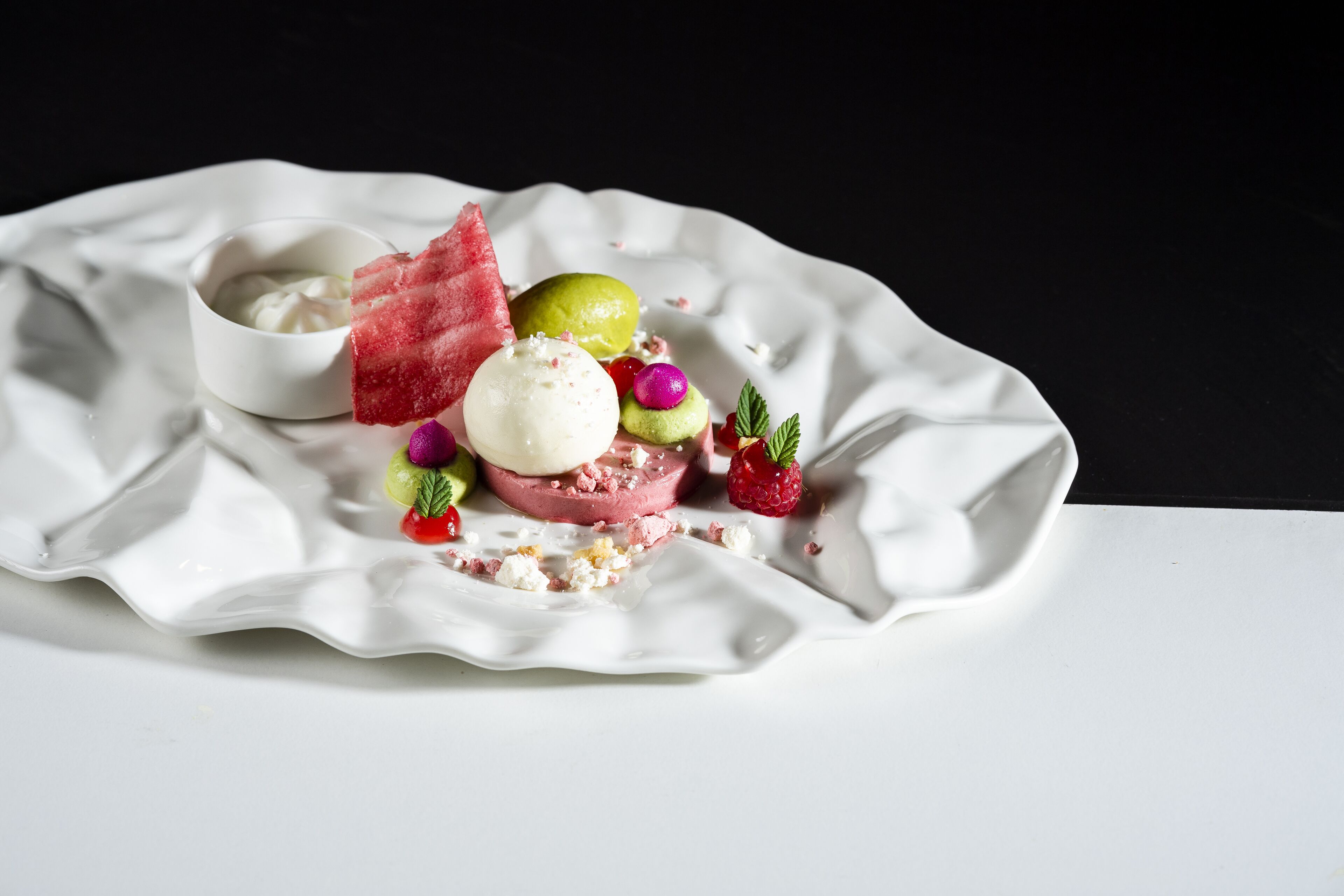 A dessert on a white plate with a black background.