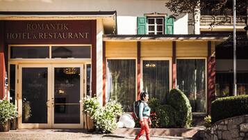 Entrada de un hotel con un letrero que dice 'Romantik Hotel & Restaurant'.