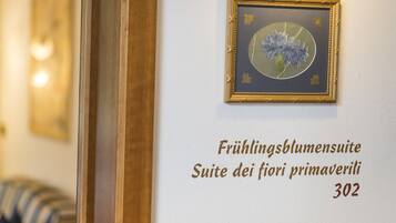 A framed artwork of flowers on a wall with text indicating room number 302.
