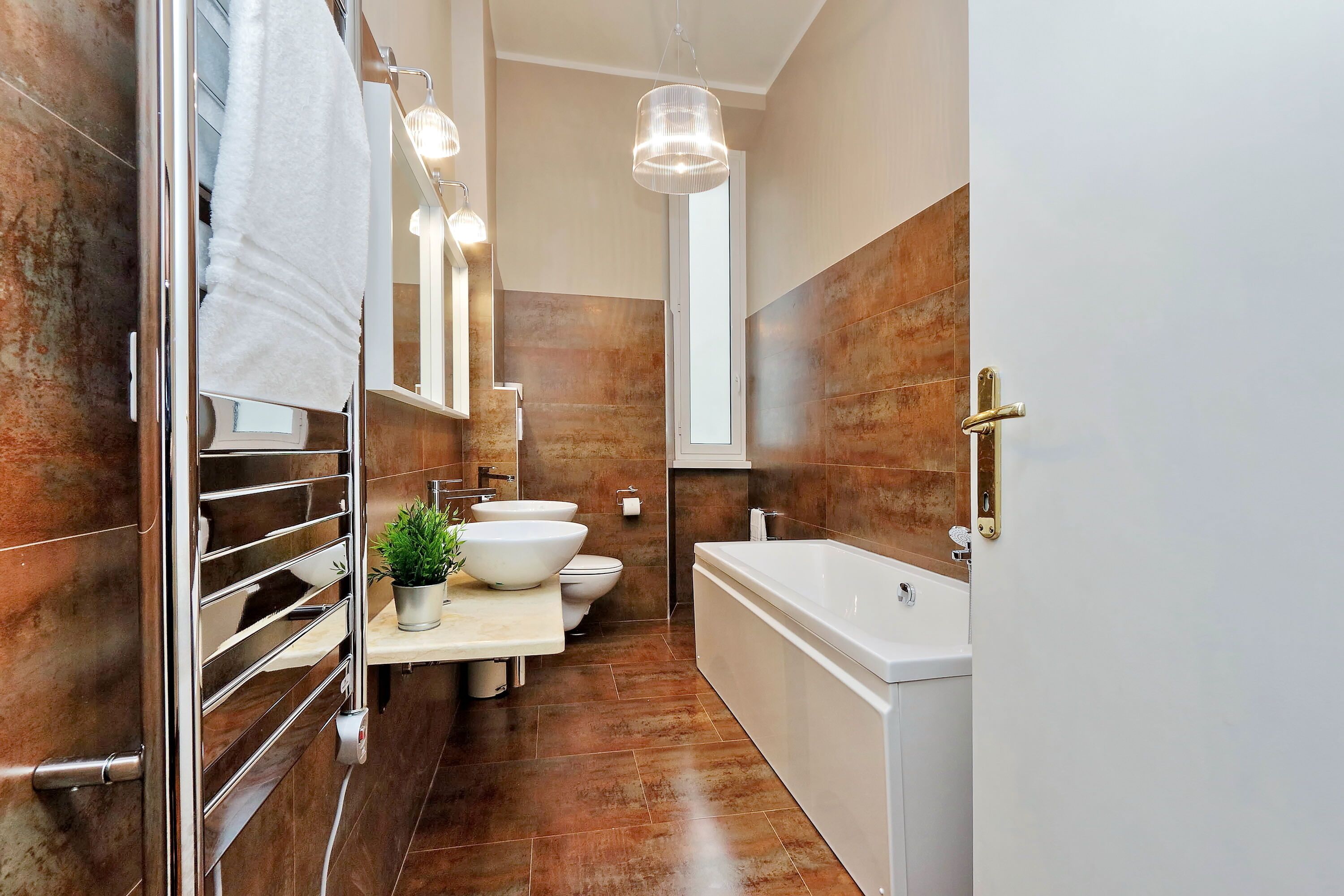 Un baño moderno con una bañera grande, un lavabo doble y un inodoro.