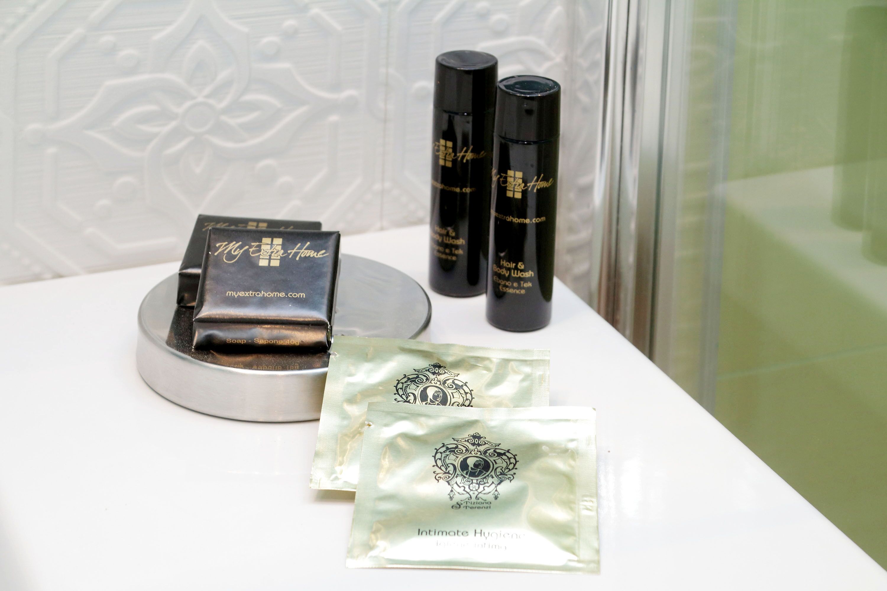 Uma toucador de banheiro com um dispensador de sabonete, uma garrafa de shampoo e uma garrafa de hidratante corporal.