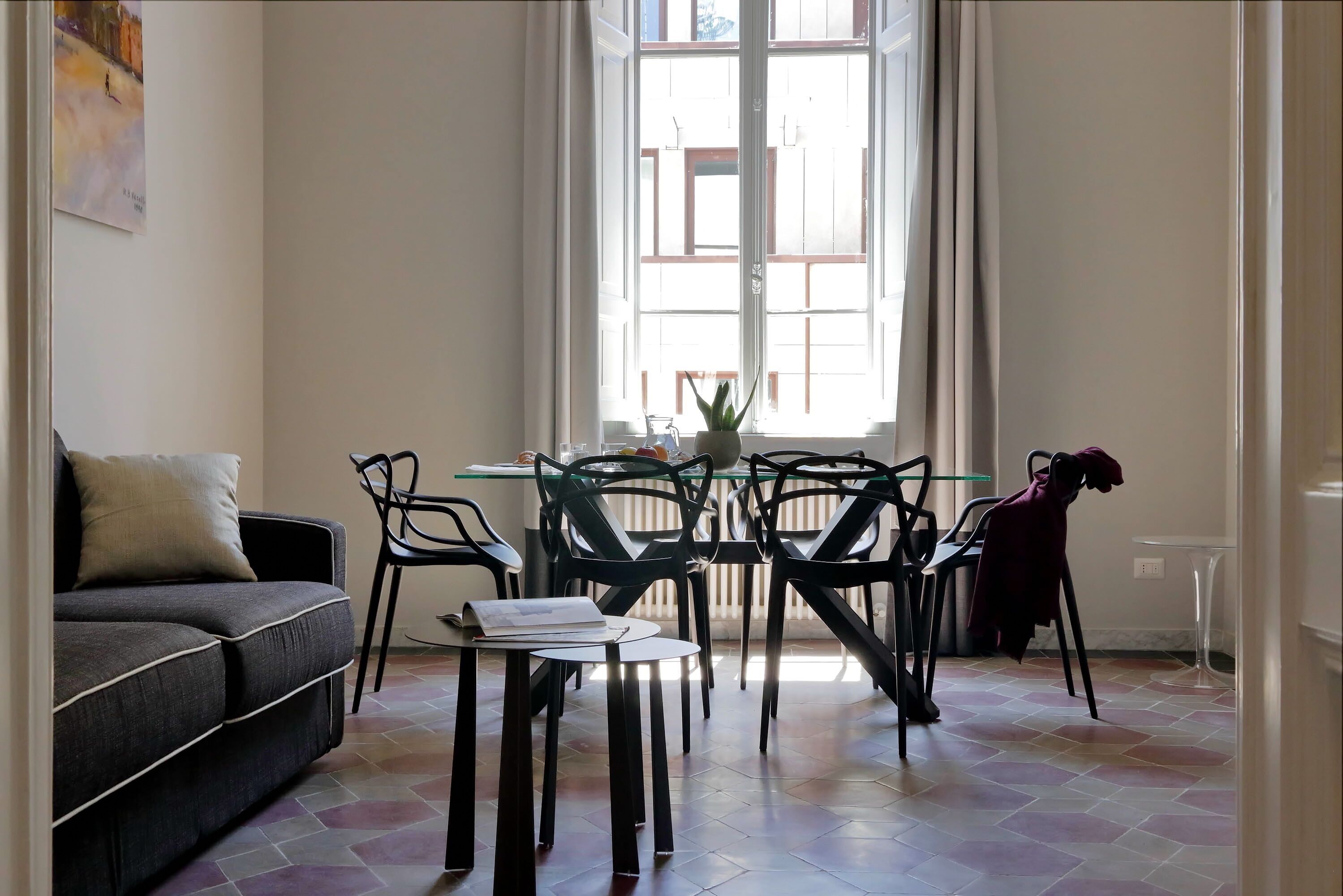 A dining area with a table, chairs, and a sofa.
