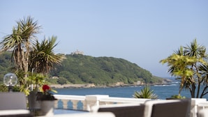 A seaside view with a hill, palm trees, and a building on top. - The Royal Duchy Hotel (Falmouth)