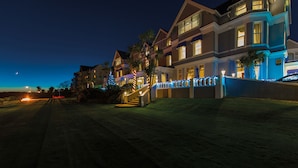 A row of multi-story houses with illuminated staircases and blue lights, set against a twilight sky. - The Royal Duchy Hotel (Falmouth)