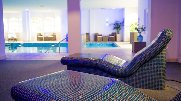 A pool area with lounge chairs and a reception desk.