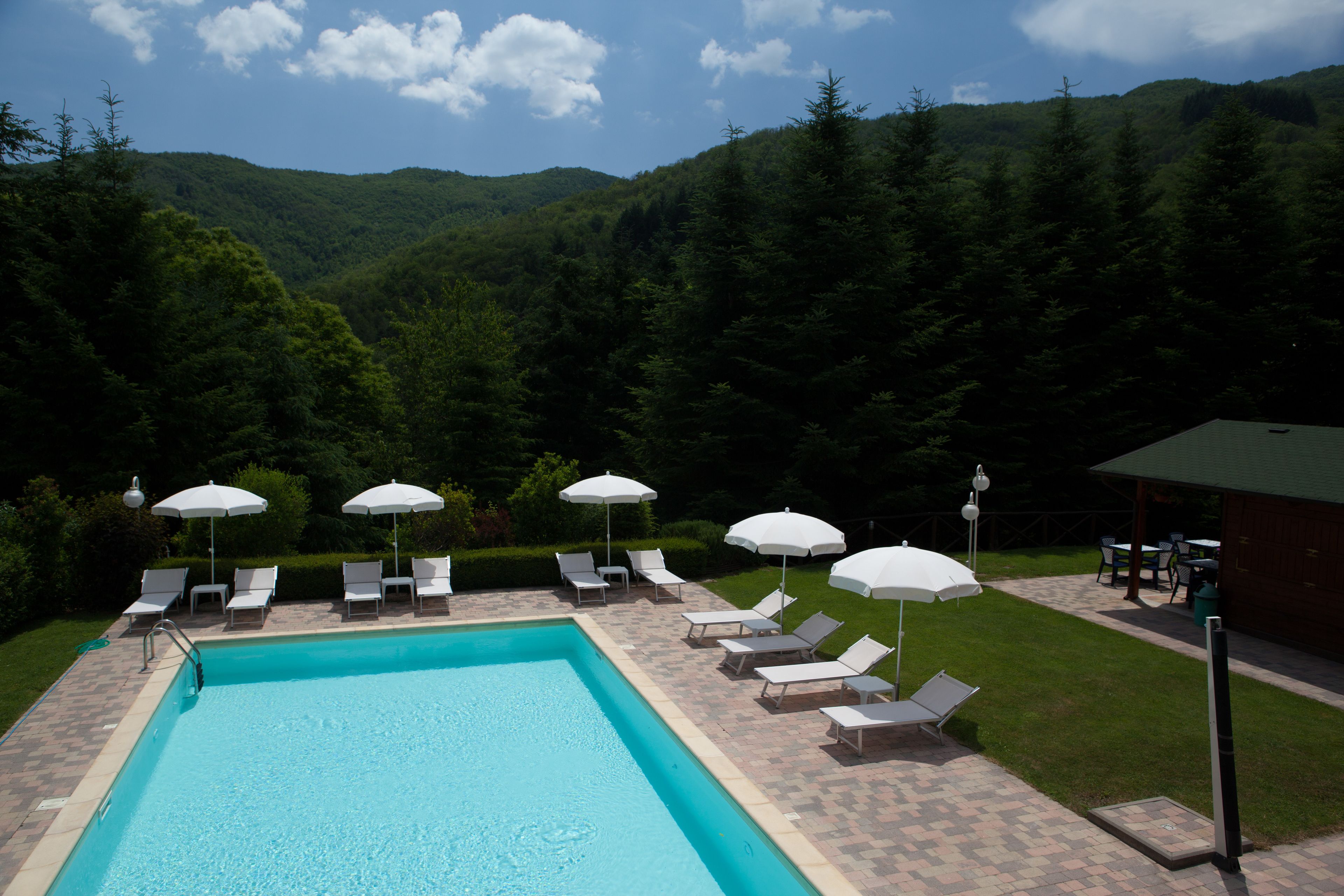 Una piscina al aire libre de temporada, sombrillas
