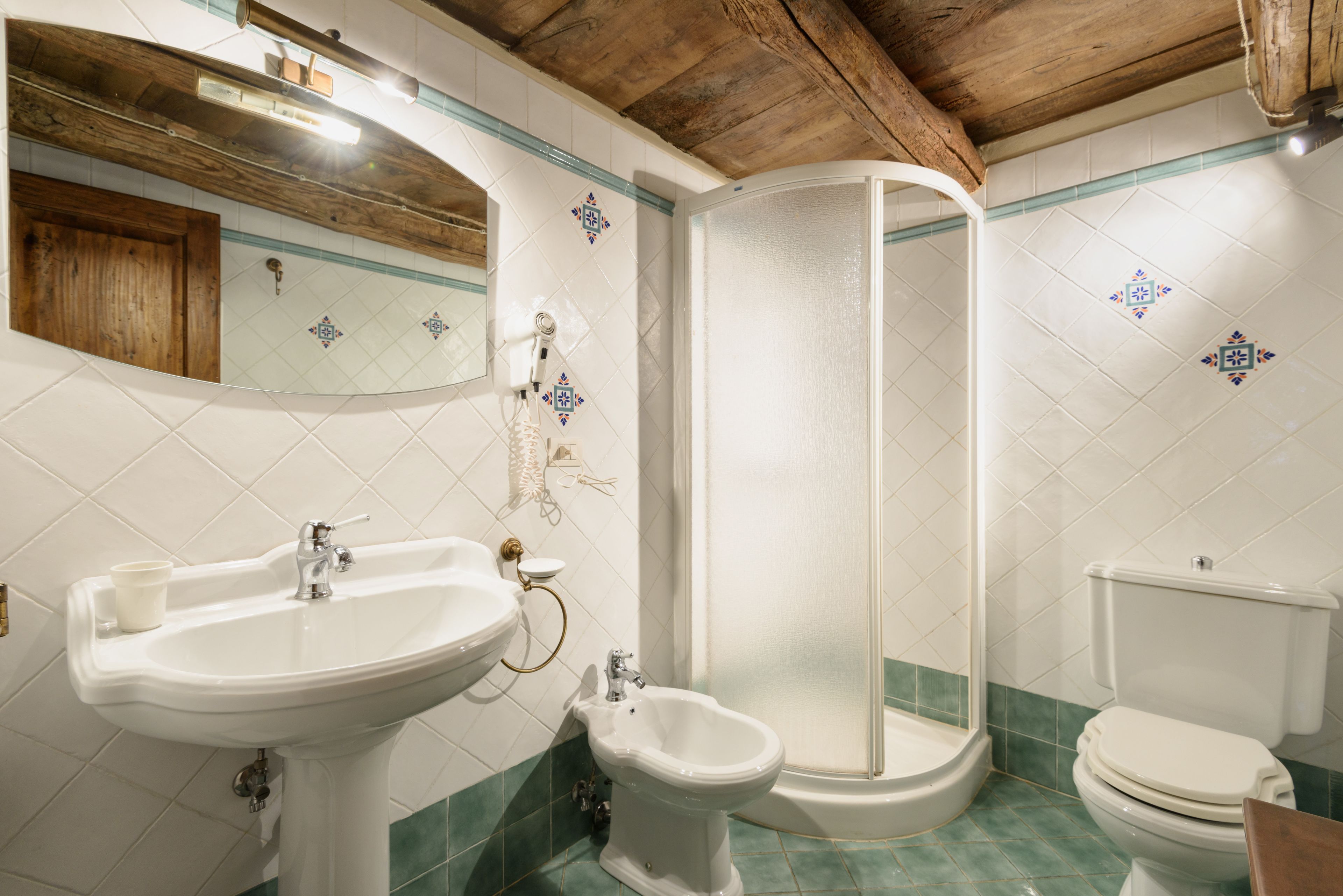 Une salle de bain équipée d’un lavabo, d’un bidet, de toilettes et d’une douche.