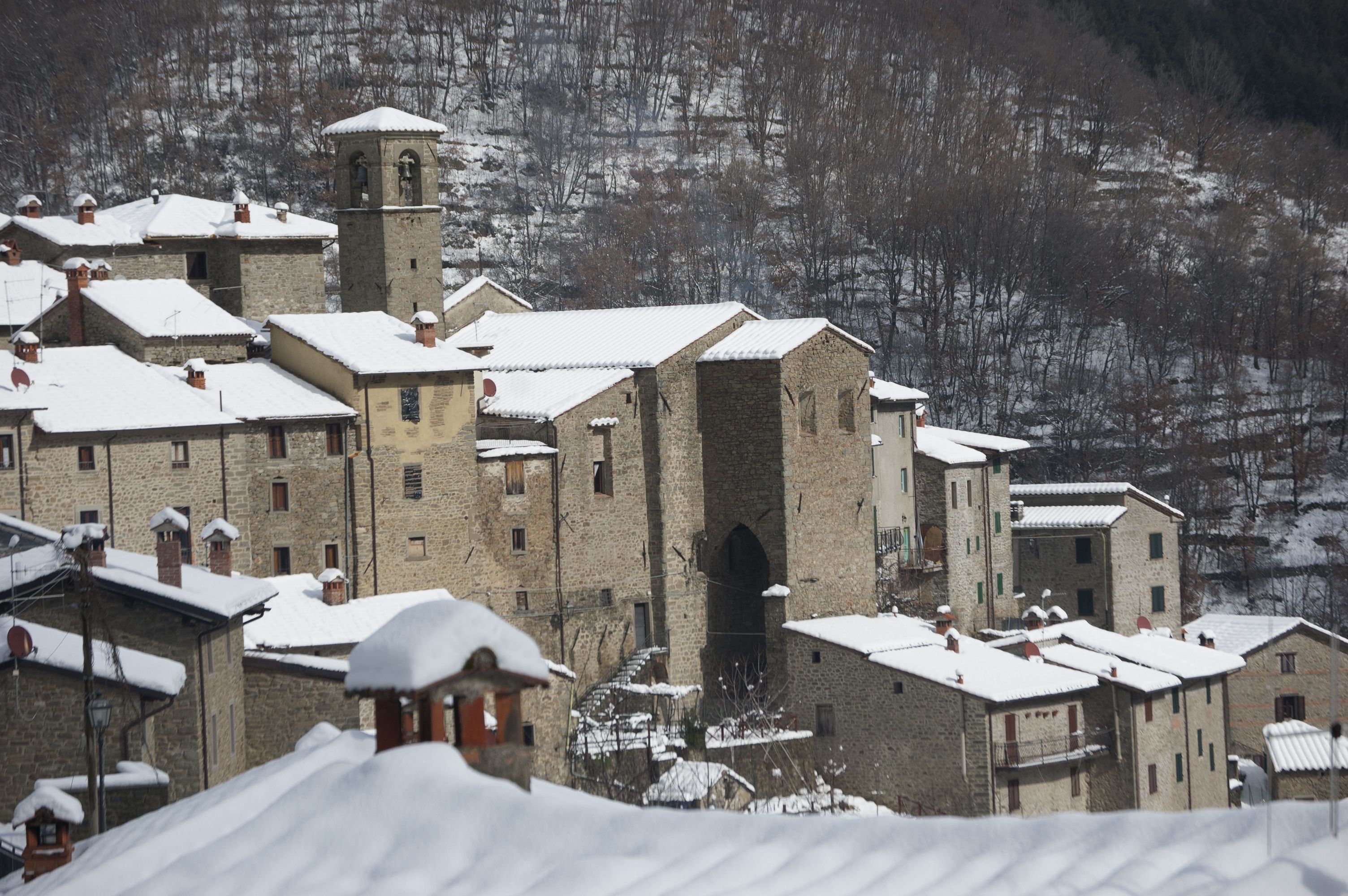A historic village with stone buildings and a prominent tower.