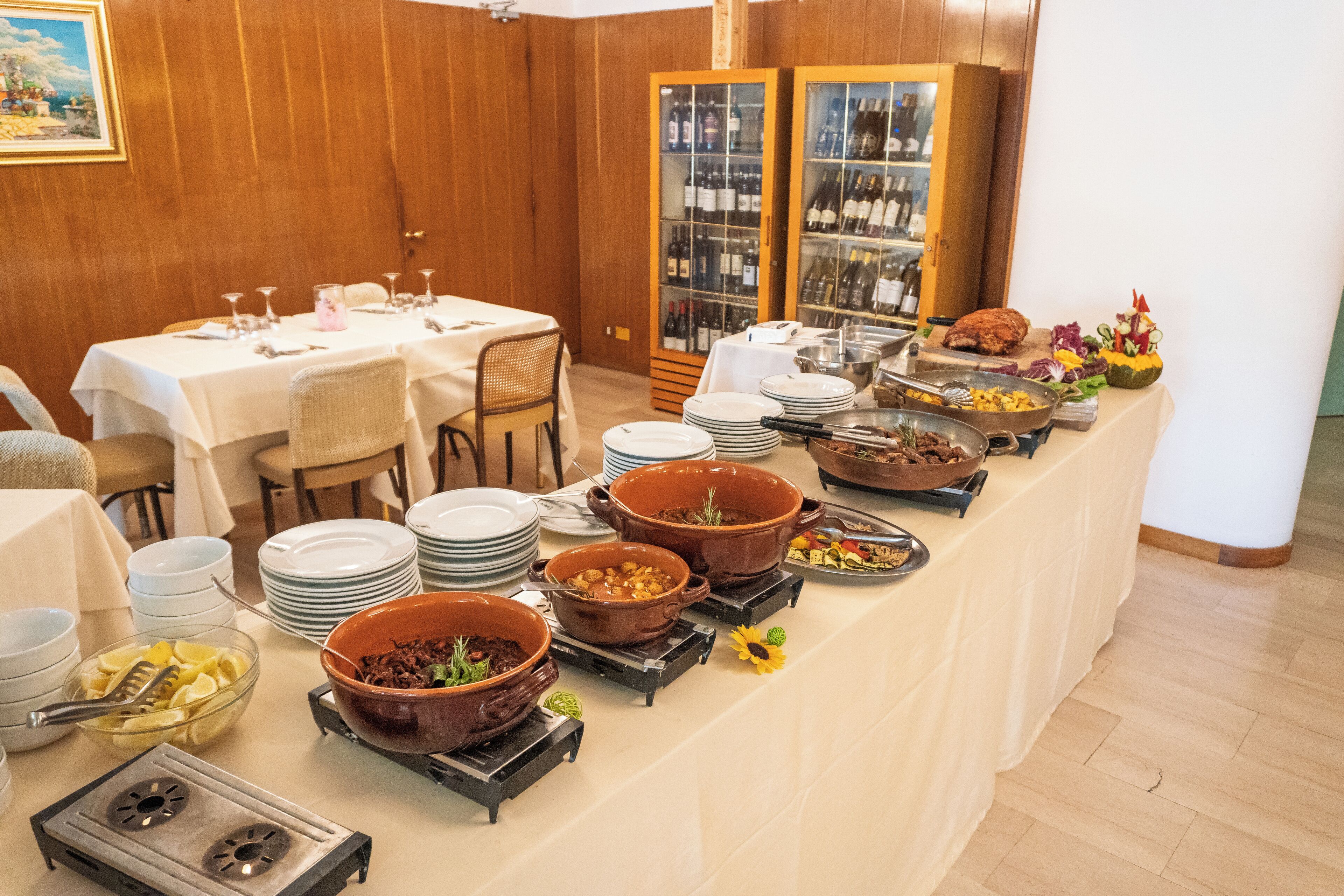 A buffet setup with multiple serving stations, including hot and cold food options, arranged on a long table.