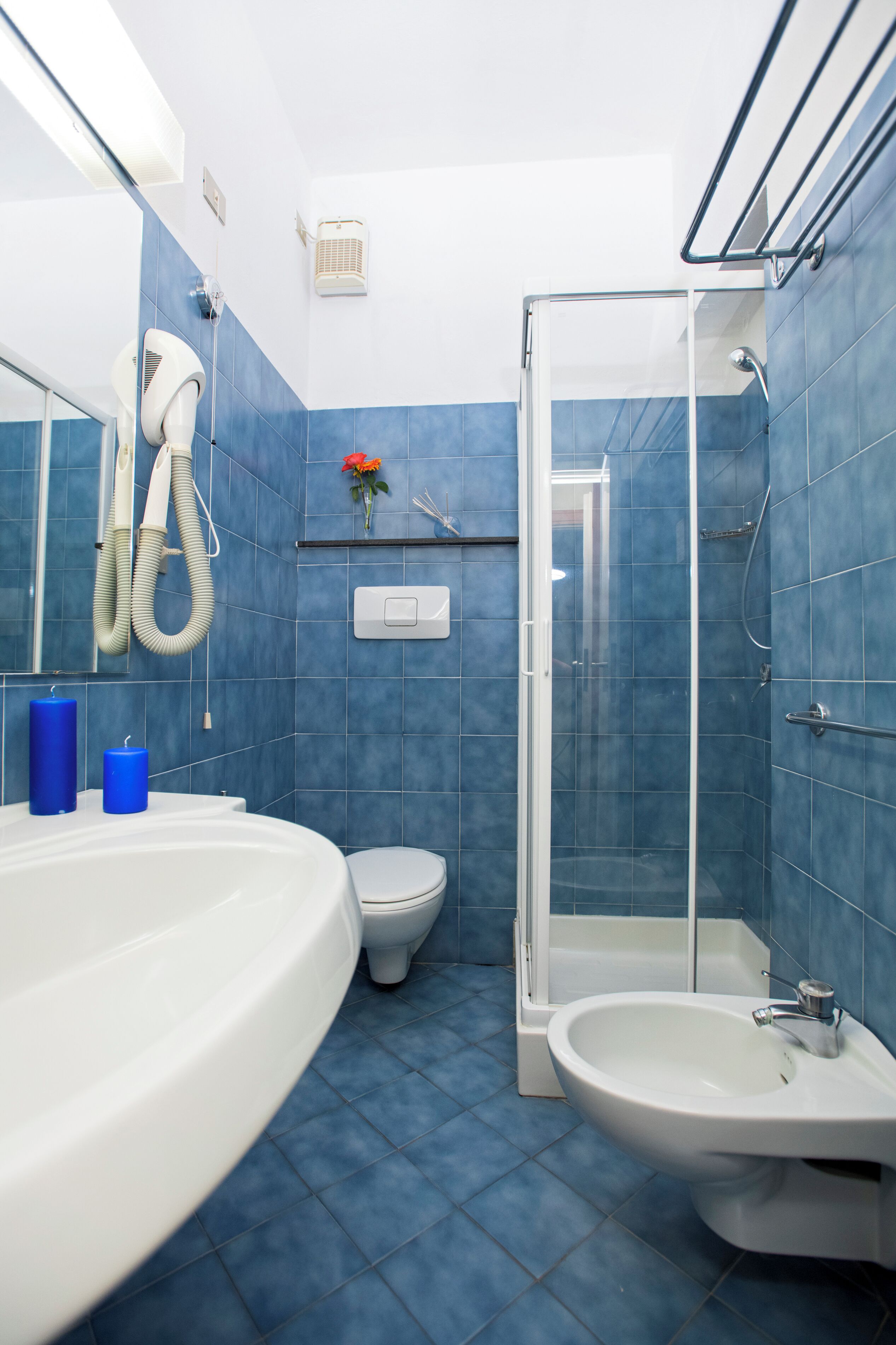A bathroom with a shower, toilet, and sink.