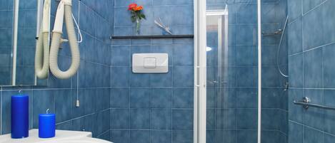 A bathroom with a shower, toilet, and sink.