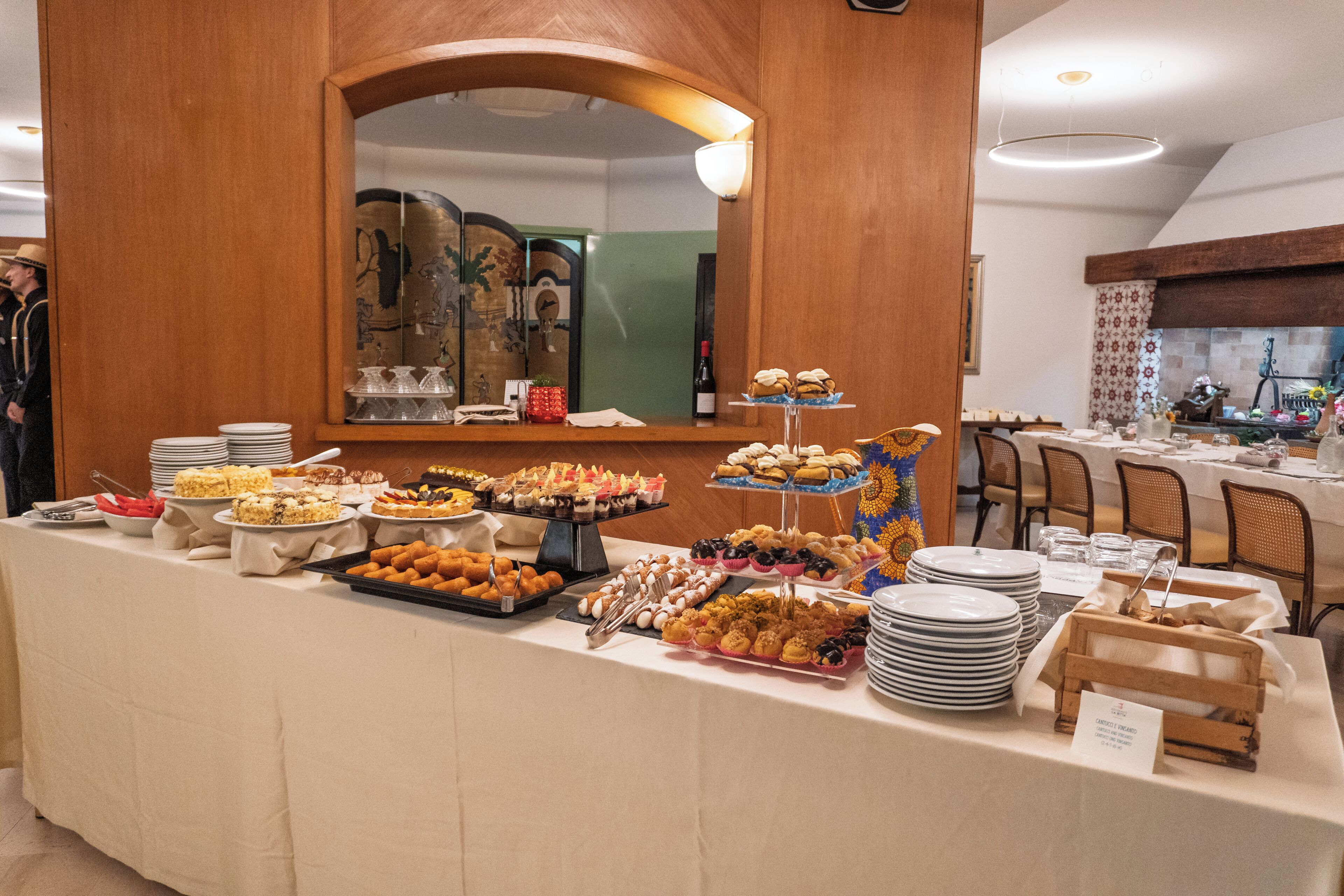 Une table de buffet garnie de différents plats et un miroir placé au-dessus.