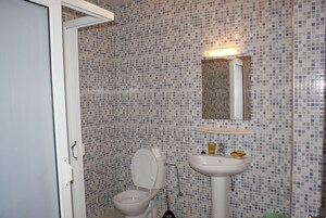 Un baño con inodoro, lavabo y espejo.