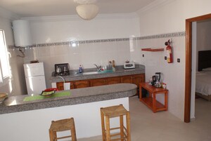 Una cocina con encimeras de granito, armarios de madera, horno empotrado y cafetera.