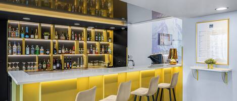 A bar area with a counter, multiple shelves of bottles, and three bar stools.