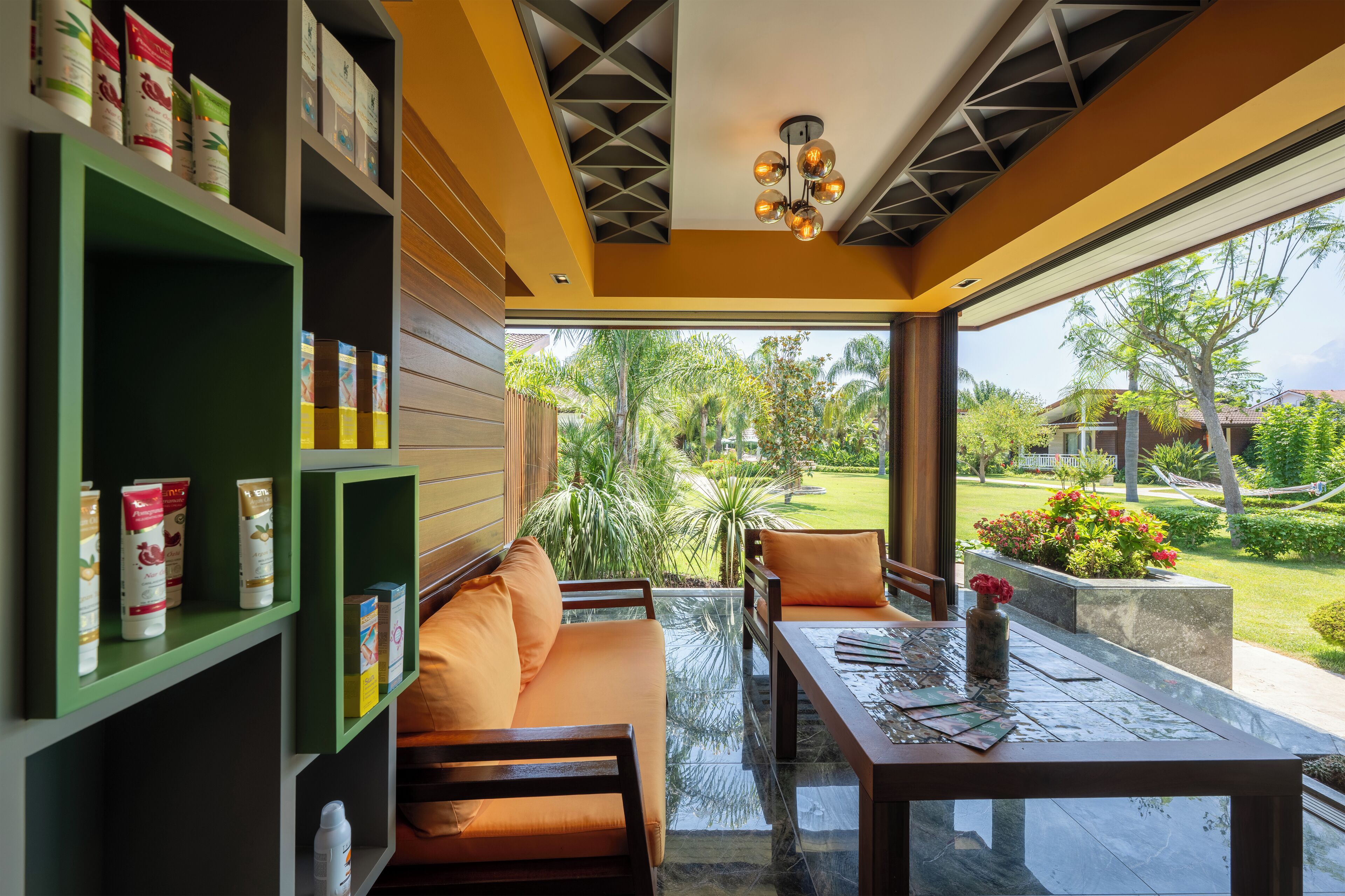 A modern interior with a sofa, chairs, a table, and shelves with products.