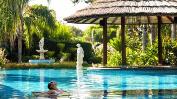 En säsongsöppen utomhuspool, parasoller och solstolar