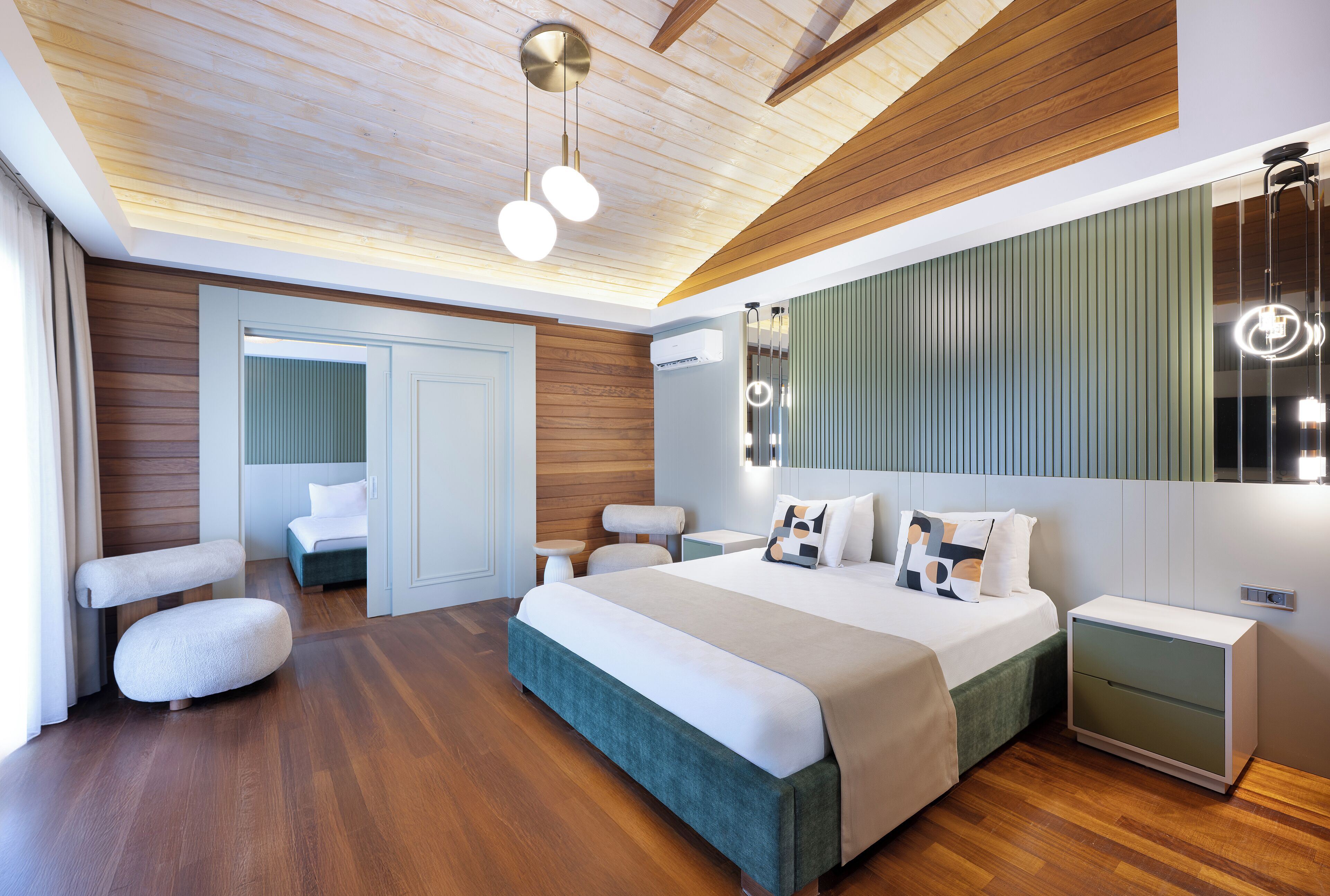 Une chambre à coucher moderne avec un grand lit, des tables de chevet, un miroir et un plafond en bois.