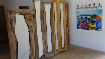 A room with a wooden structure, possibly a furniture piece, and a colorful painting on the wall.