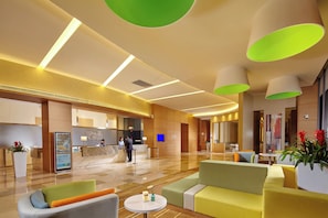 A modern hotel lobby with a reception desk, seating area, and a digital information kiosk. - Holiday Inn Express Shanghai Jiading Industry Park by IHG (Shanghai)