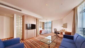 A hotel room with a bed, a desk, a TV, and a seating area with a coffee table. - Holiday Inn Express Shanghai Jiading Industry Park by IHG (Shanghai)
