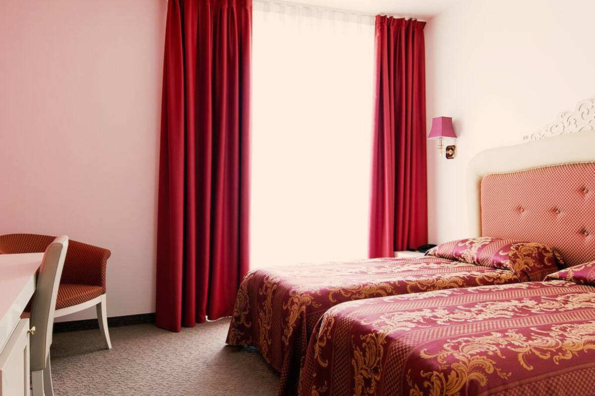 Een slaapkamer met twee bedden, een bureau en een stoel.