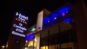 Une enseigne d’hôtel sur laquelle on peut lire « Hôtel Palace » et « La Conchiglia d’Oro Ristorante ».