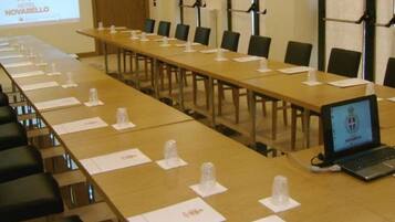 A conference room with a long table, chairs, name cards, and a laptop.