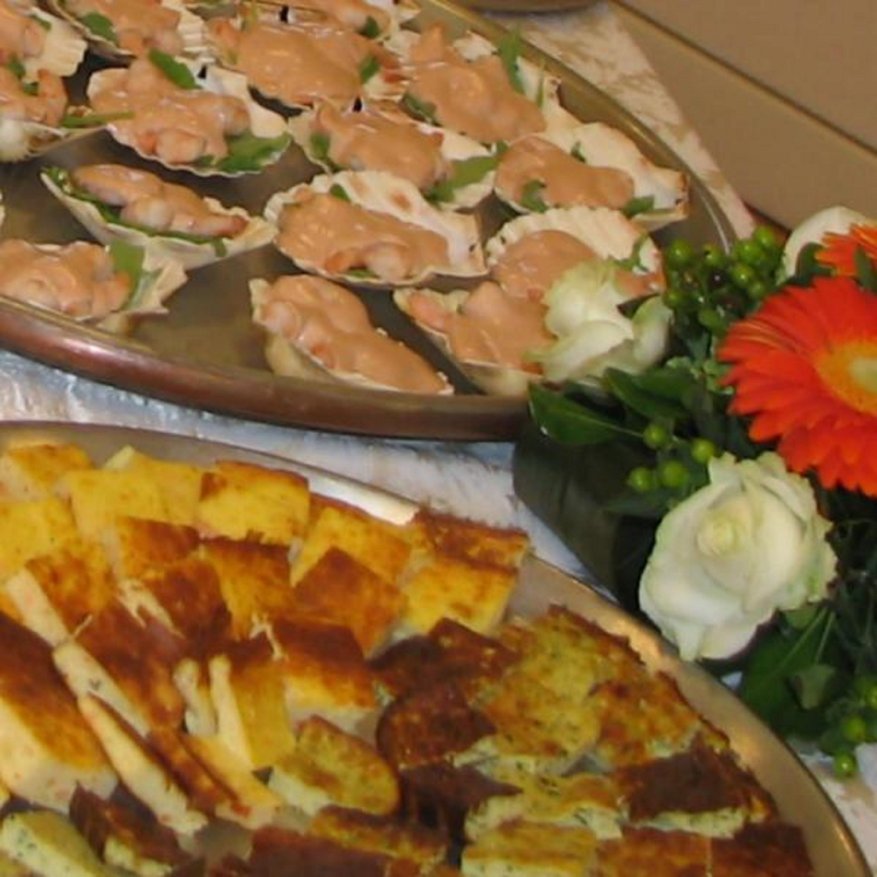 Una bandeja con alimentos, incluyendo camarones y posiblemente algún tipo de pan o bollería, dispuesta sobre una mesa.
