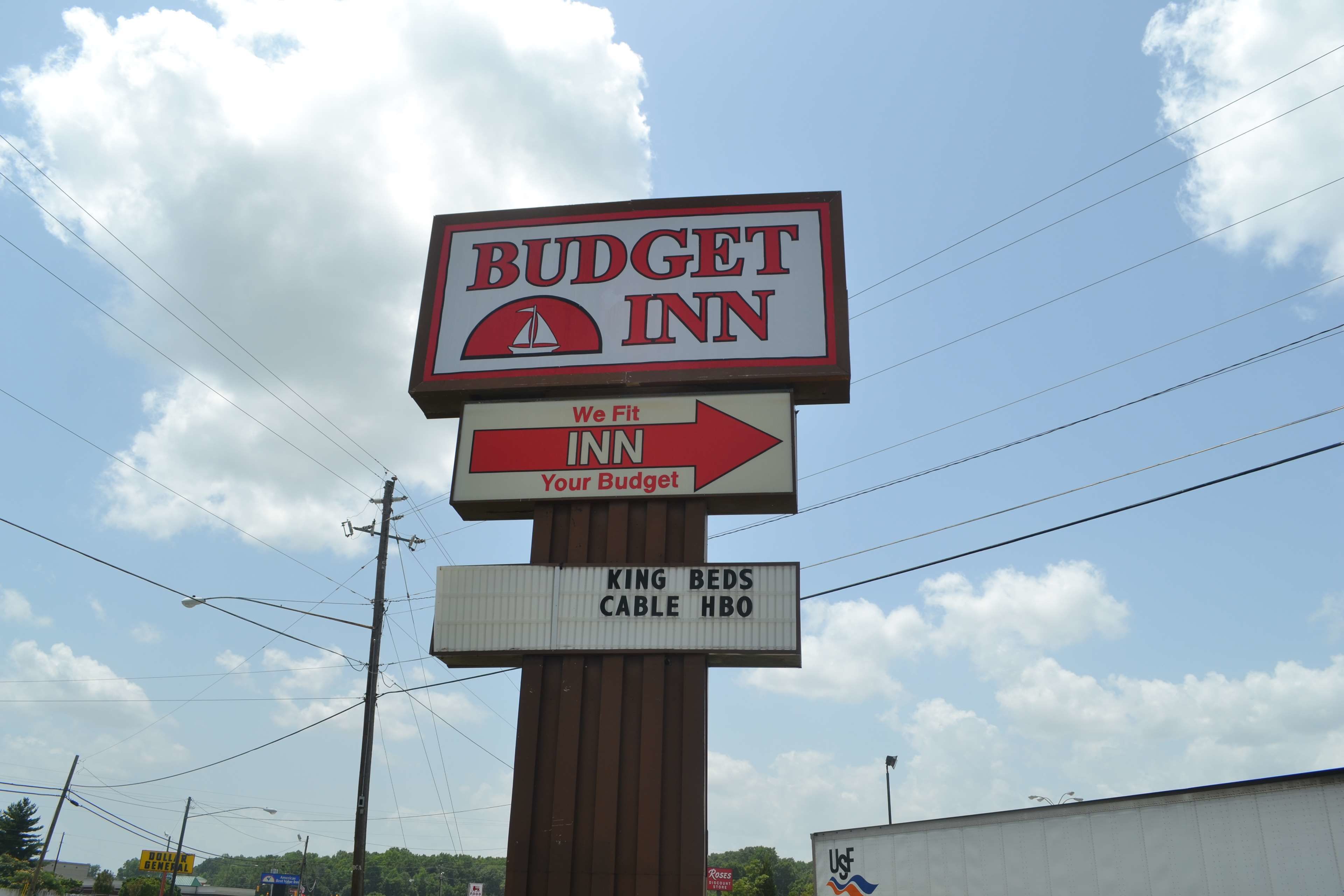 Une enseigne indiquant le « Budget Inn », avec une flèche directionnelle pointant vers la droite.