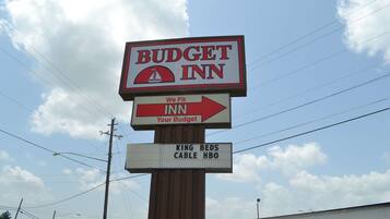 Une enseigne indiquant le « Budget Inn », avec une flèche directionnelle pointant vers la droite.