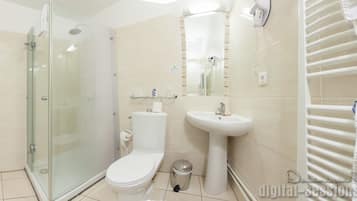 A modern bathroom with a glass-enclosed shower, a white toilet, a pedestal sink, and a towel rack.