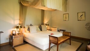 A bedroom with a bed, bedside tables, a chair, and a wall-mounted fan.