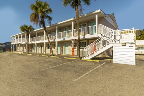 Un motel de varios pisos, con una escalera y un estacionamiento.