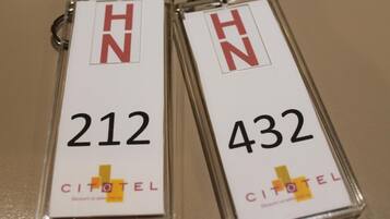 Two keychains with the letters "HN" and numbers "212" and "432" on them, and the word "CITOTEL" at the bottom.