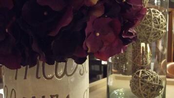A vase with purple flowers and a decorative glass container with spherical objects.