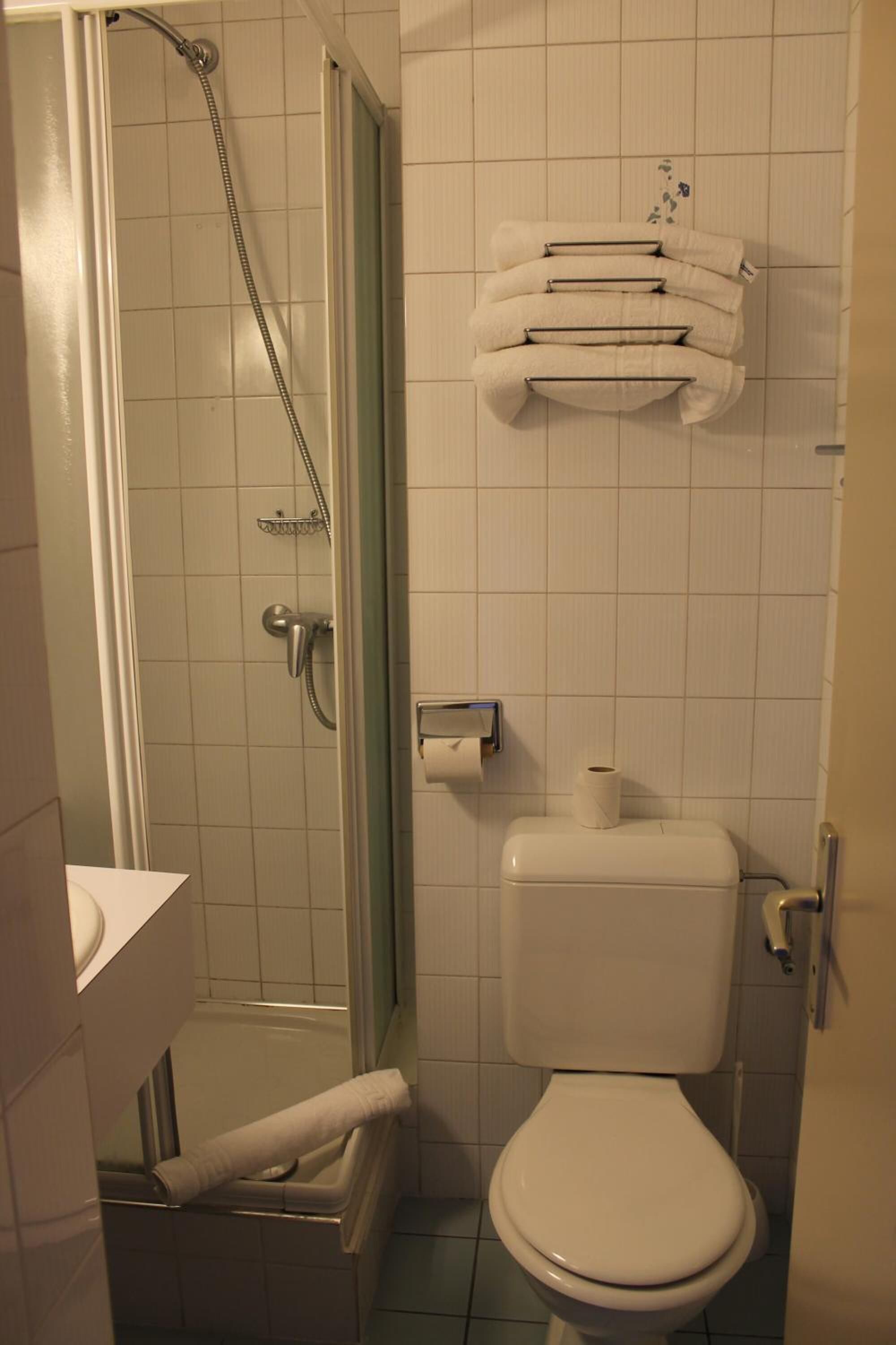 A bathroom with a shower, toilet, and sink.