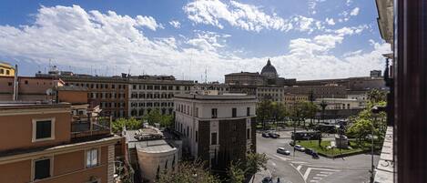 Un paisaje urbano con un edificio destacado con cúpula, rodeado de otros edificios y un cielo despejado.